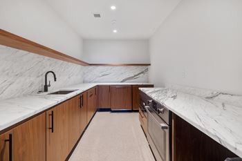 A kitchen with marble counter tops and wooden cabinets